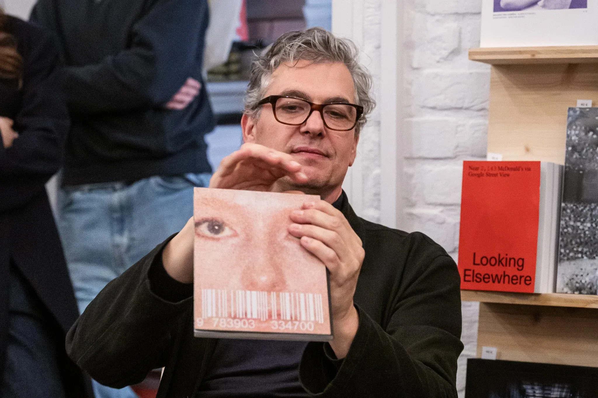 Felix Hoffmann showing the special way this photobook is bound.
