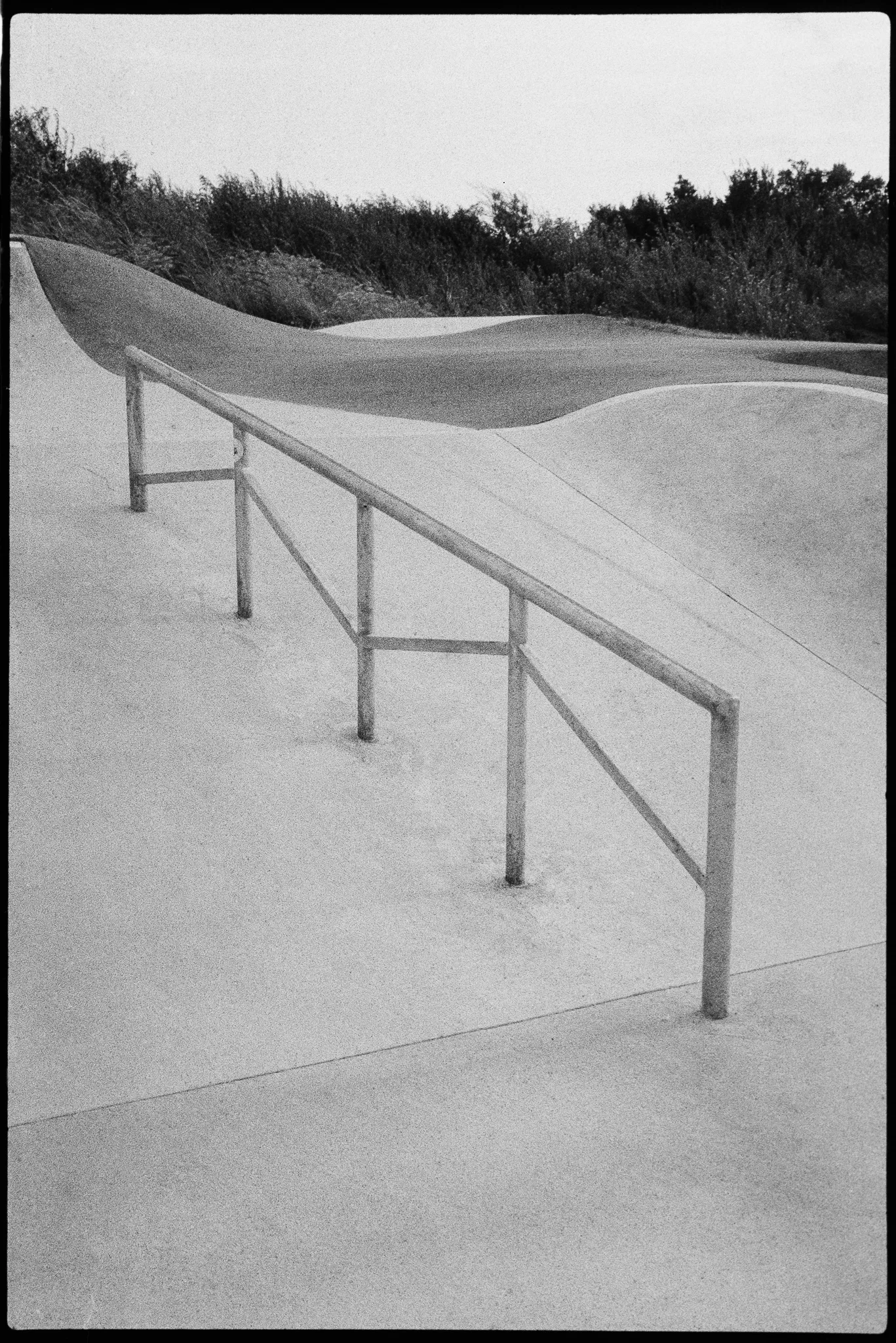 Handrail in an empty skatepark, black-and-white film, July 2024