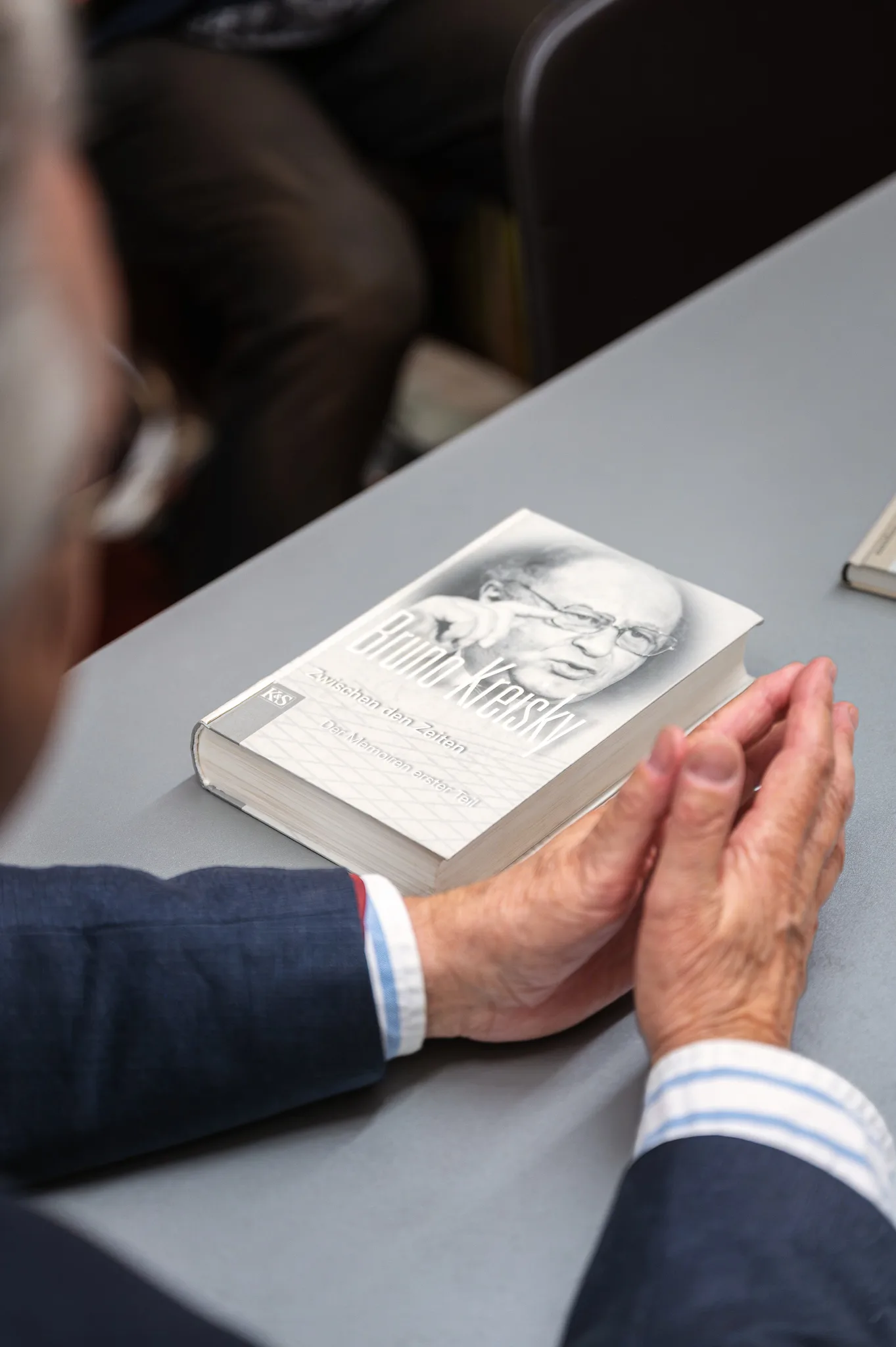 Hands resting on a book about Bruno Kreisky, Bruno Kreisky Archive, Vienna, 2026